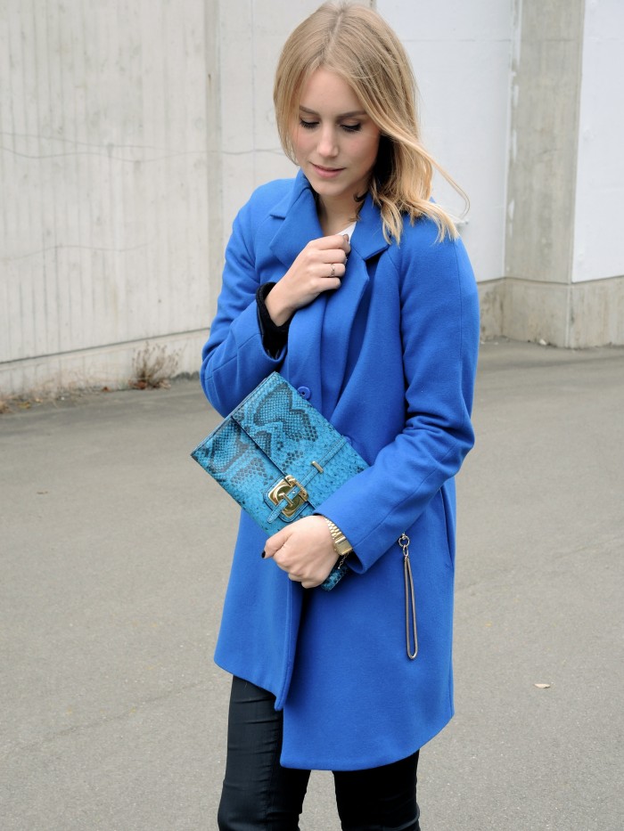 Königsblauer Mantel mit blauer Clutch in Schlangenoptik