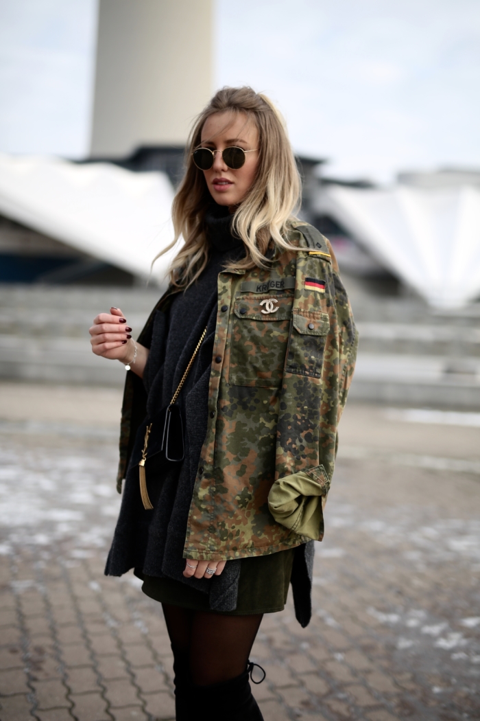 Camouflage-Jacke mit Chanel Brosche, schwarzer Kuschelpulli, overknee Stiefel