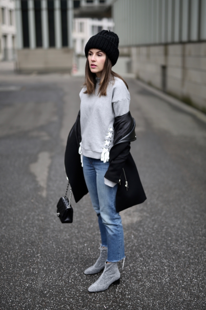 grey sweater, black coat, jeans, grey boots, beanie