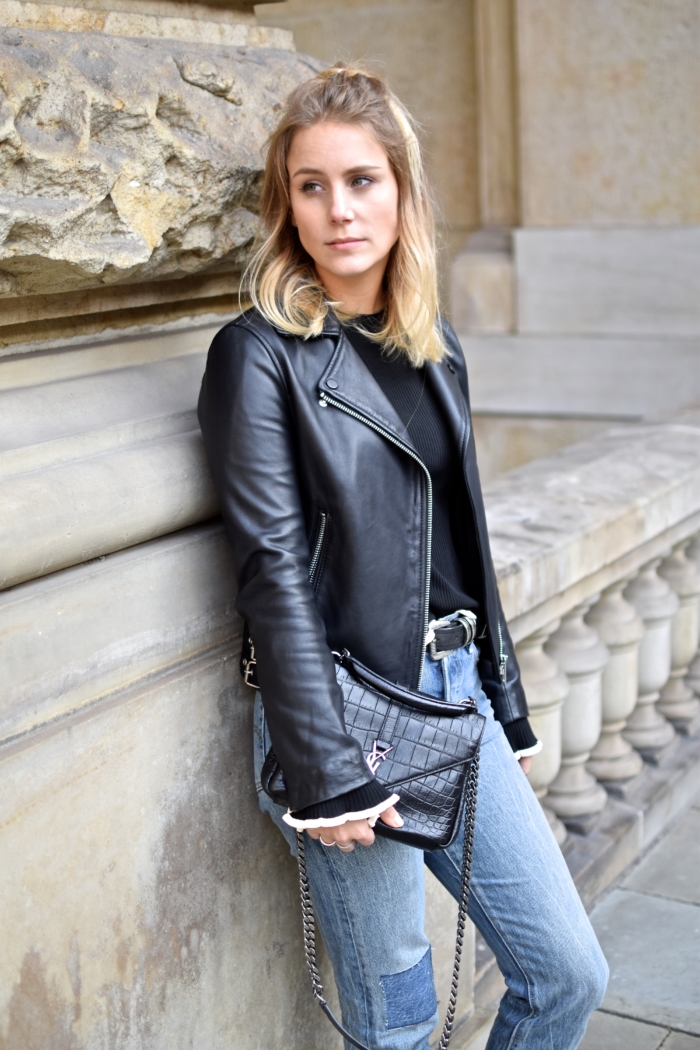 leather jacket, black sweater, black bag, blonde halfbun