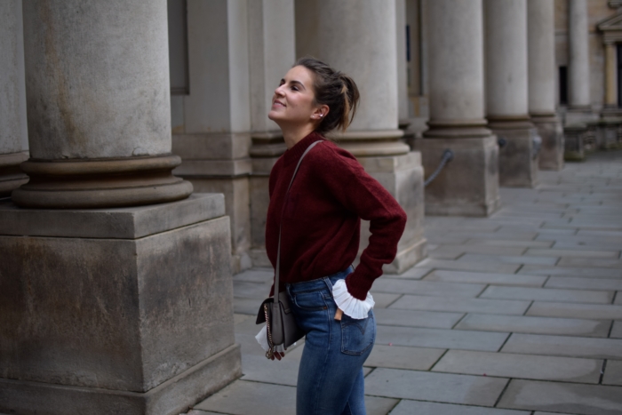 Levis Jeans, roter WoodWood Sweater, weiße Rüschenbluse
