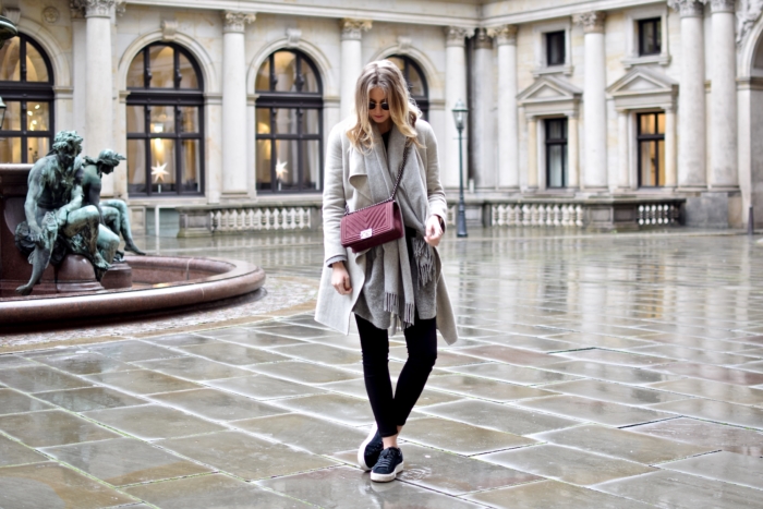 rote Handtasche, grauer Mantel, Schal, schwarze Hose, Sneakers