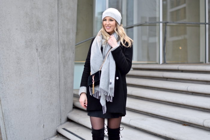 black winter coat, grey scarf, hat, black purse