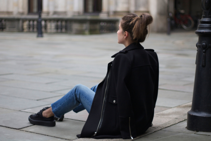 black coat, jeans, fishnet socks