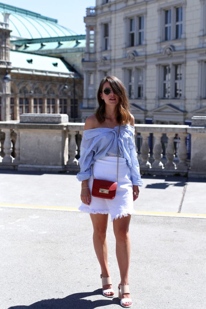 weiße Shorts, blaue Blose geknotet, rote Tasche