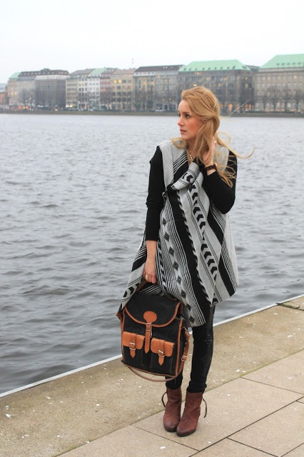 Gemusterter Cardigan, schwarze Hose, braune Tassel Boots und braun schwarze Tasche