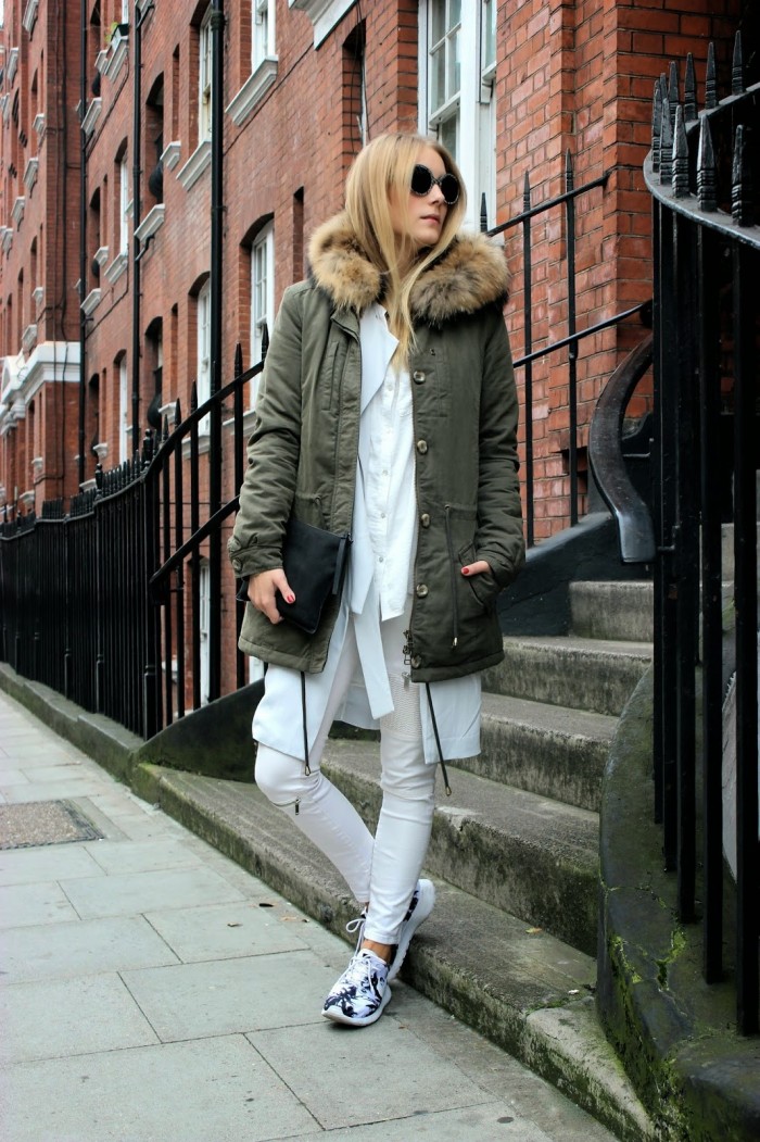 Khakifarbener Parka mit weißer Bluse und weißer Hose