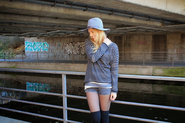 Grauer Hut und schwarzgrau gestreifter Pullover