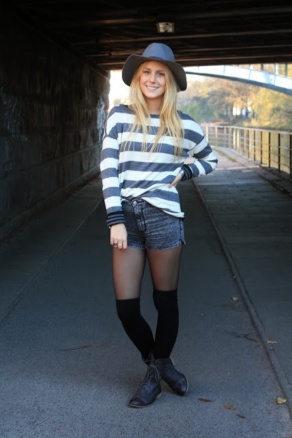 Grauer Hut, gestreifter Pullover und graue shorts