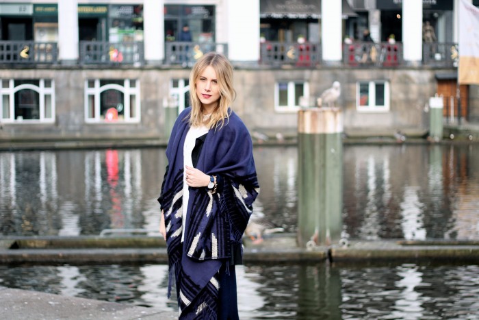 Blond girl wearing blue poncho by TK Maxx