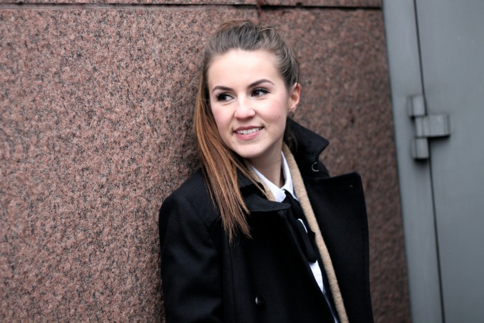 smiling girl with a bun and a black coat